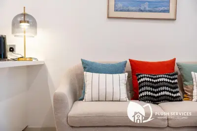 a living room with a couch with colorful pillows at The Signature Serviced Apartment at Sri Hartamas in Kuala Lumpur