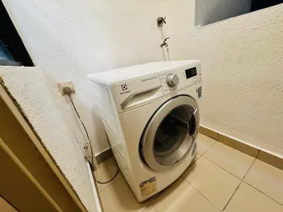 a washing machine in a corner of a room at Velocity KL by Homestay in Kuala Lumpur