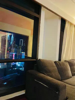 a living room with a couch and a large window at Royal empire suite At Times square kl in Kuala Lumpur
