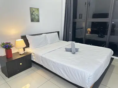 a bedroom with a large bed with white sheets at KLCC View 1BR cozy suite with Balcony Trion B5310 KL in Kuala Lumpur