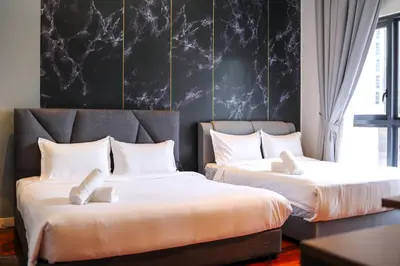 a bedroom with two beds with white pillows at The Mews KLCC by GB in Kuala Lumpur