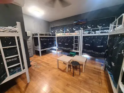 a dorm room with bunk beds and a table and chairs at Regalia Infinity Skypool in Kuala Lumpur