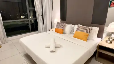 a bedroom with a large white bed with a window at Balcony Cityscape III The Robertson Residence 41f in Kuala Lumpur