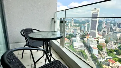 a table and chairs on a balcony with a view of a city at Balcony Cityscape III The Robertson Residence 41f in Kuala Lumpur