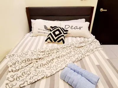 a bed with a black and white blanket and pillows at Mini Studio Near Gleneagles 10 mins to KLCC in Kuala Lumpur