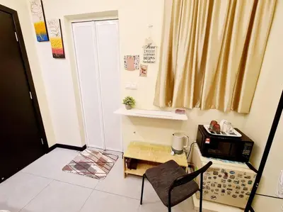 a kitchen with a microwave and a chair in a room at Mini Studio Near Gleneagles 10 mins to KLCC in Kuala Lumpur