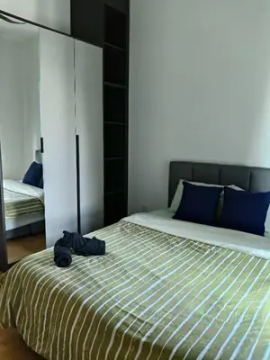 a bedroom with a large bed with blue pillows at 2BR Centre MontKiara 4px 500Mbps in Kuala Lumpur