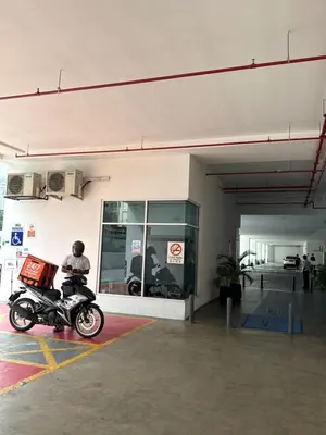 a person riding a motorcycle in a parking garage at 2BR Centre MontKiara 4px 500Mbps in Kuala Lumpur