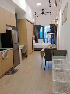 a kitchen and living room with a table and a couch at The Luxe KLCC by NZ in Kuala Lumpur