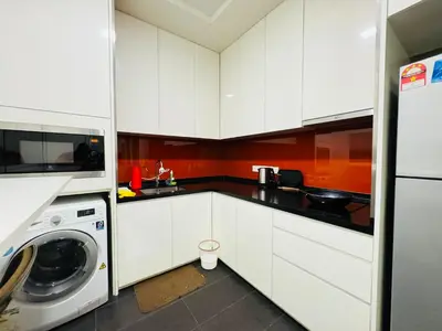 a kitchen with white cabinets and a washer and dryer at Arcoris Residence Mont Kiara by DeUrban in Kuala Lumpur