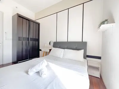 a bedroom with a large white bed with white sheets at Una Serviced Apartment by Manhattan Group in Kuala Lumpur
