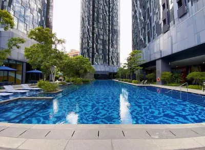 a large blue swimming pool in a building with tall buildings at Star Luxury By Star Residences KLCC in Kuala Lumpur