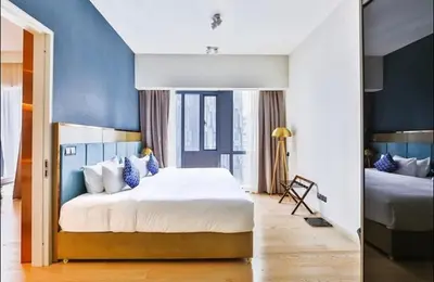 a bedroom with a large bed with blue walls at Star Luxury By Star Residences KLCC in Kuala Lumpur