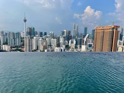 a view of a city skyline from the water at 1BR condo with Amazing KLCC View & Infinity Pool at Lalaport Bukit Bintang in Kuala Lumpur