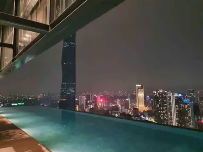 a swimming pool with a view of the city at night at 1BR condo with Amazing KLCC View & Infinity Pool at Lalaport Bukit Bintang in Kuala Lumpur
