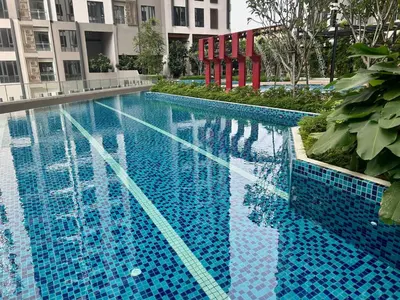 a large blue swimming pool with a building at KL Central 33rd Floor KLCC view in Kuala Lumpur