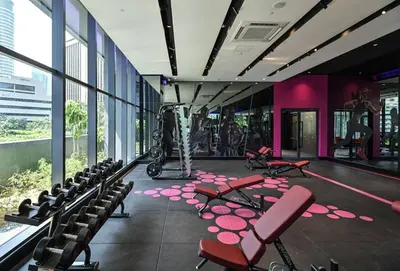 a room with chairs and a gym with purple walls at Star Xtian Residence KLCC in Kuala Lumpur