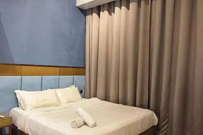 a bed with two white towels on top of it at Star Xtian Residence KLCC in Kuala Lumpur