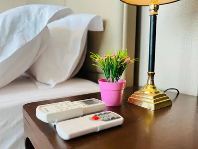 a table with two remote controls and a lamp at Dorsett Sri Hartamas by DeUrban in Kuala Lumpur