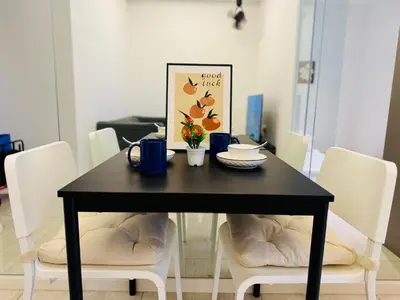 a black dining room table with white chairs and a picture at Dorsett Sri Hartamas by DeUrban in Kuala Lumpur