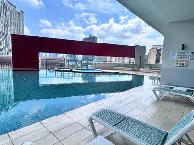a swimming pool on the roof of a building at Private Cinema and Jacuzzi at Pertama Residency in Kuala Lumpur