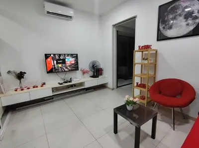 a living room with a television and a red chair at Private Cinema and Jacuzzi at Pertama Residency in Kuala Lumpur