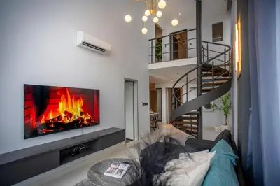 a living room with a fireplace and a tv at Novo Kuala Lumpur by Cobnb, Jalan Ampang in Kuala Lumpur