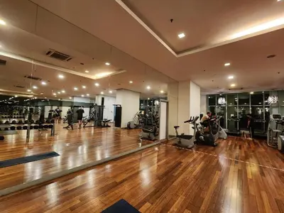 a gym with a wooden floor and people exercising in it at Infinity Pool Hostel in Kuala Lumpur