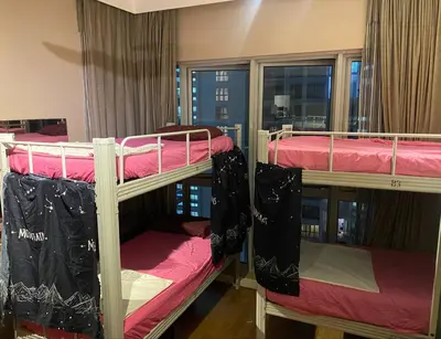 two bunk beds in a room with a window at Infinity View KL Hostel in Kuala Lumpur