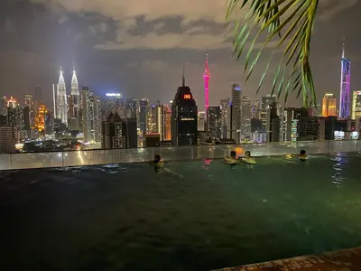 a rooftop swimming pool with a city skyline at night at Celestial Heights Hostel featuring Infinity Skypool in Kuala Lumpur