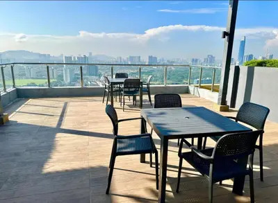 a patio with tables and chairs and a view of the city at Rainbowstudioklcc in Kuala Lumpur