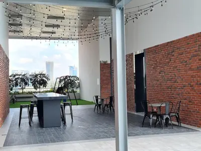 a patio with tables and chairs and a brick wall at Chambers Suites KLCC By City Homes in Kuala Lumpur