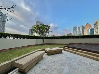 a park with two benches and a wall with buildings at ABC PRiVATE RooM Klcc in Kuala Lumpur