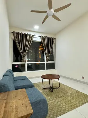 a living room with a blue couch and a ceiling fan at ABC PRiVATE RooM Klcc in Kuala Lumpur