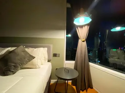 a bedroom with a bed and a table and a window at Apartment Sky by MonoSuites KLCC in Kuala Lumpur