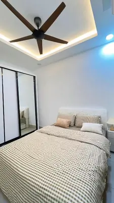 a bedroom with a bed with a ceiling fan at Inara Homestay in Kuala Lumpur
