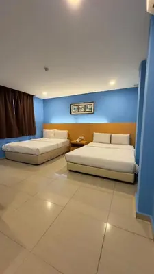 two beds in a room with blue walls at South of The Clouds HOTEL KL Sentral \u5409\u9686\u5761\u5f69\u4e91\u4e4b\u5357\u9152\u5e97-\u4e2d\u592e\u8f66\u7ad9\u5e97 in Kuala Lumpur