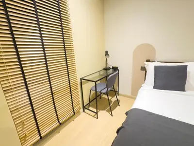a bedroom with a bed and a desk next to a window at Family comfy 2BR at Star residence2 KLCC in Kuala Lumpur