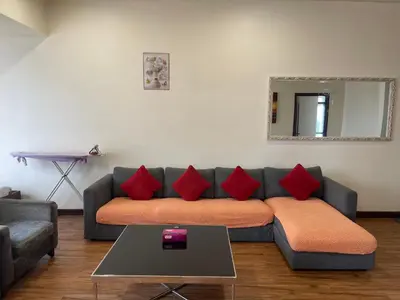 a living room with a couch with red pillows at KL Elegant Apartment at Times Square in Kuala Lumpur