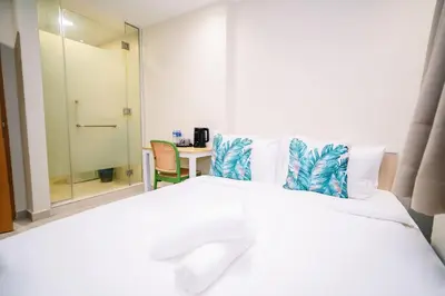 a bedroom with a large white bed and a table at Swing & Pillows - Times Square, Bukit Bintang in Kuala Lumpur