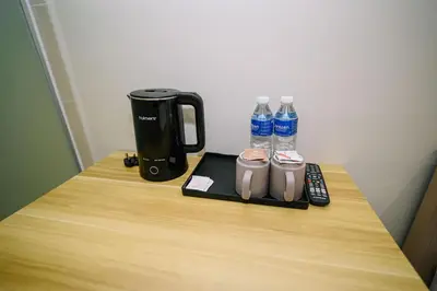 a table with a coffee maker and two bottles of water at Swing & Pillows - Times Square, Bukit Bintang in Kuala Lumpur