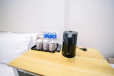 a coffeemaker sitting on a table with bottles of water at Swing & Pillows - Times Square, Bukit Bintang in Kuala Lumpur
