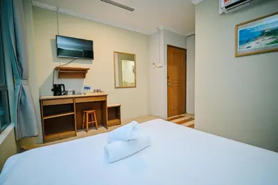 a hotel room with a bed and a television at Swing & Pillows - Petaling Street Kuala Lumpur in Kuala Lumpur