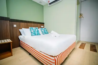 a bedroom with a large white bed with blue pillows at Swing & Pillows - Petaling Street Kuala Lumpur in Kuala Lumpur
