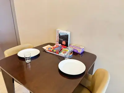 a wooden table with two plates and a box of food at Dorsett Residence Sri Hartamas by Chengal with Bathtub, Rooftop Pool, KL City Centre, Round the Clock Security, Netflix, Youtube, Free Parking in Kuala Lumpur