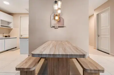 a wooden bench in a kitchen with a table at Cozy Apartment with KLCC View & 1 Min to LRT Station in Kuala Lumpur