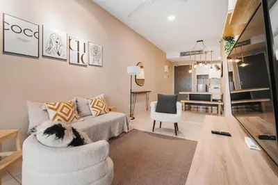 a living room with a couch and a chair at Cozy Apartment with KLCC View & 1 Min to LRT Station in Kuala Lumpur
