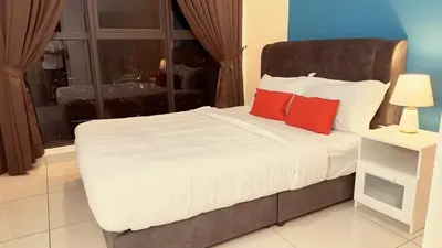 a bedroom with a bed with red pillows and a window at KLCC view 1BR service suite with Balcony Trion B5311 KL in Kuala Lumpur