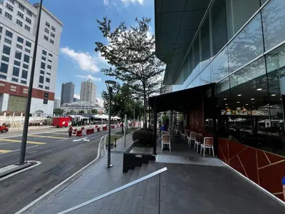 a city street with a building and tables and chairs at THE COLONY INFINITUM Sweet Home SR in Kuala Lumpur