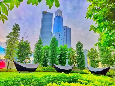 two hammocks in a park in front of a city at Lila Suites Agile, Bukit Bintang ,KLCC in Kuala Lumpur